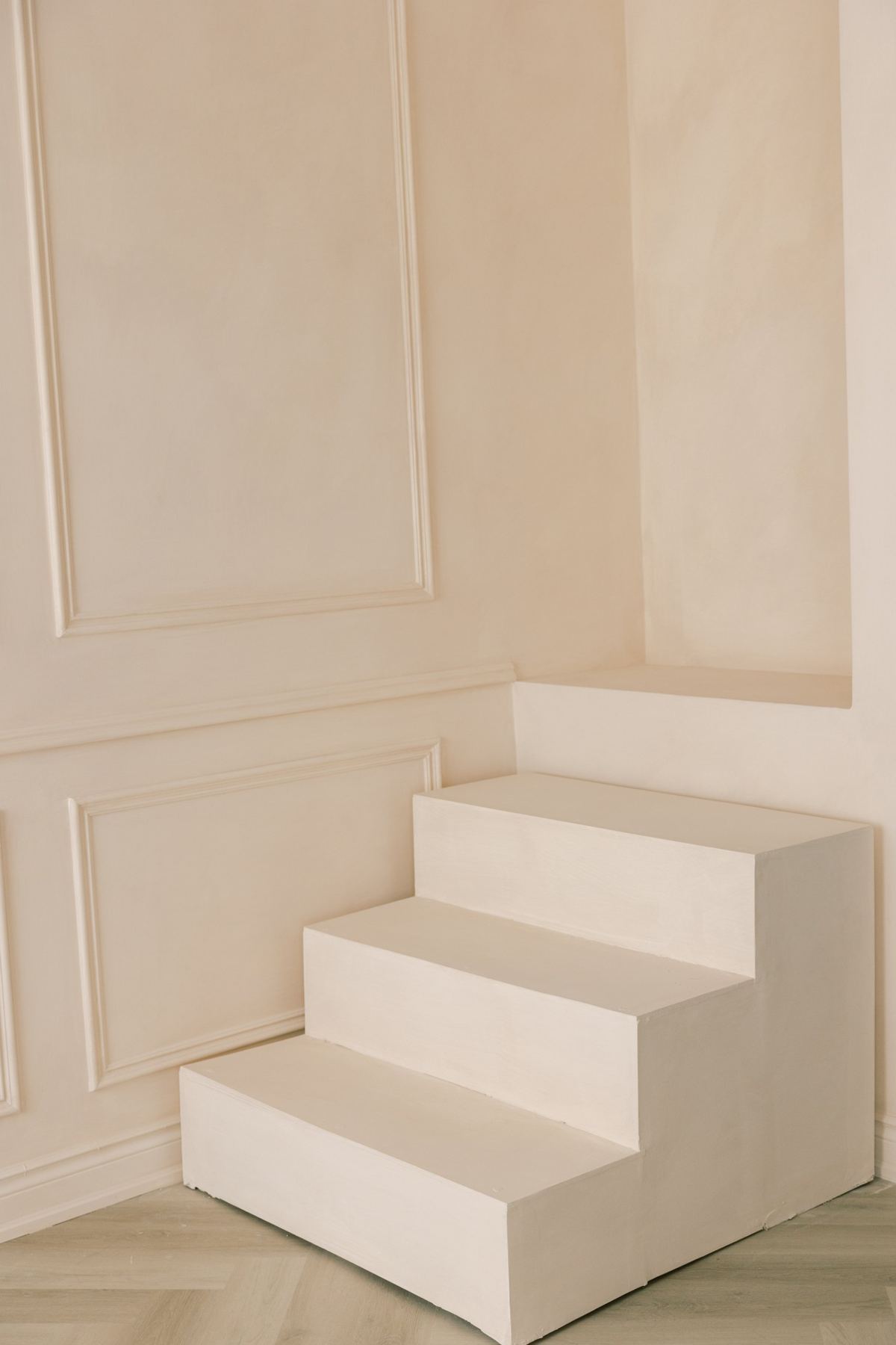Limewashed plaster steps against paneled molding walls with a soft, cloudy texture